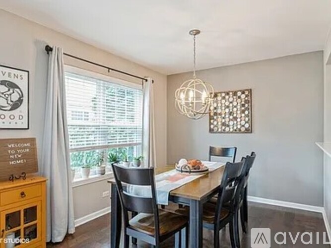 A dining room with a wooden table and chairs.