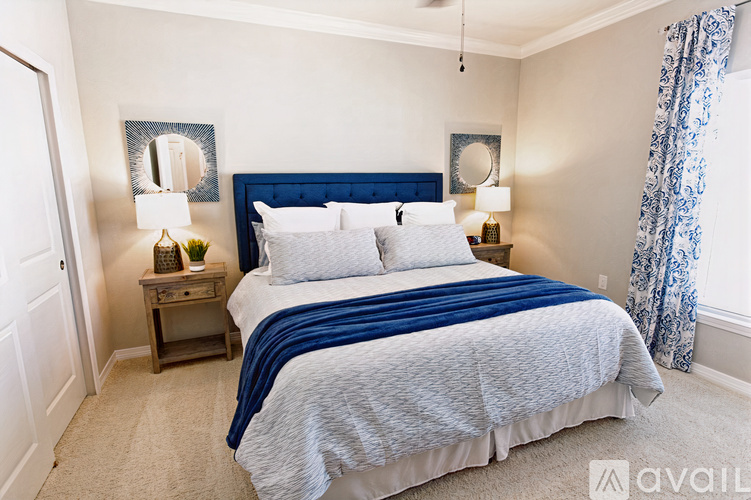 A bedroom with a large bed and two nightstands.