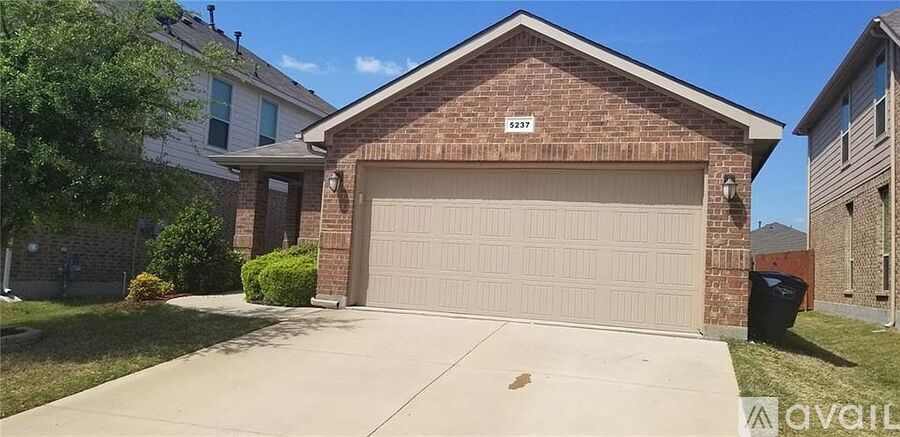 A two-car garage is attached to a brick house.