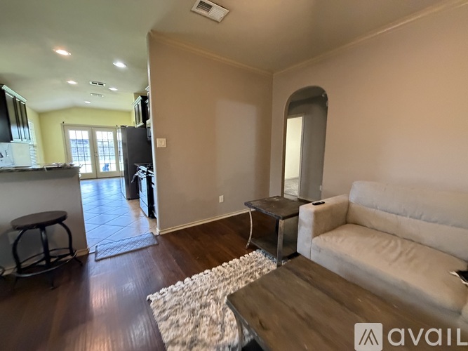 A living room with a white couch and a wooden coffee table.