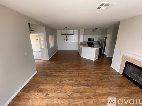 A spacious living room with hardwood floors and a fireplace.