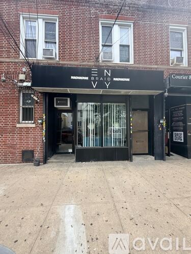 The entrance to a building with a black awning that reads "EN BRAID VY".