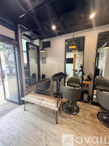A hair salon with a mirror and chairs.