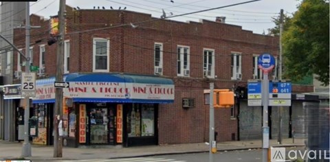 A street view of a building with a blue awning and a sign that reads "Wine & Spirits".