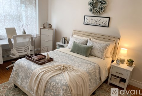 A bedroom with a large bed and a wreath on the wall.
