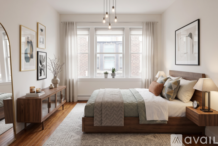 A well-lit bedroom with a large bed and a window with curtains.