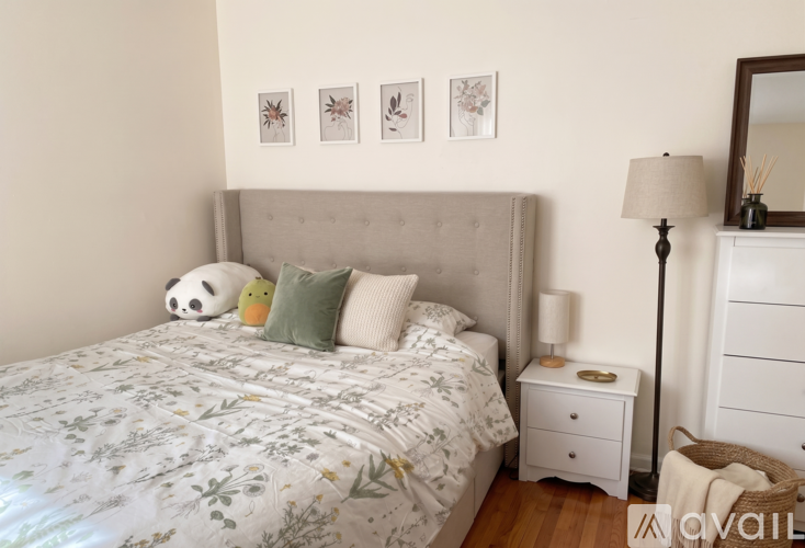 A bedroom with a floral bedspread and a grey headboard.