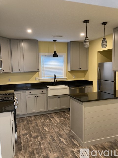 A kitchen with a black countertop and white cabinets.