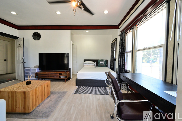 A modern bedroom with a large bed and a flat screen TV.
