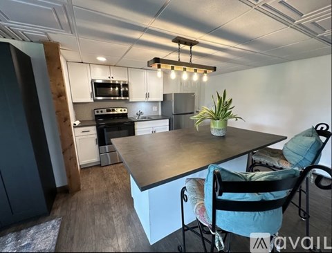 A kitchen with a table and chairs.