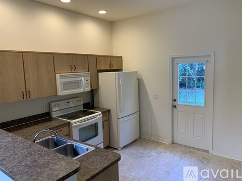 A kitchen with a sink, stove, and refrigerator.