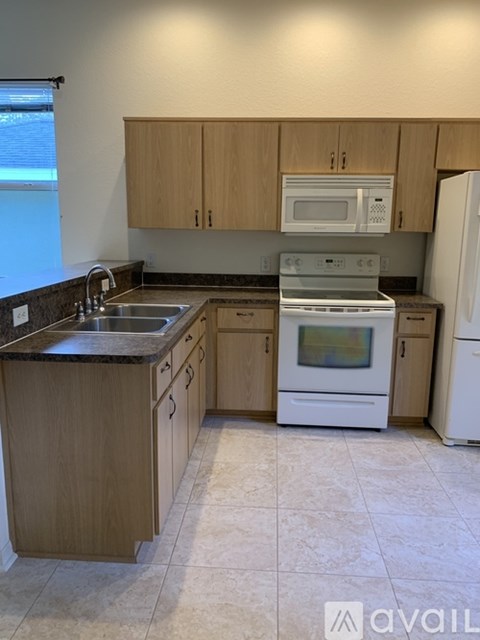 A kitchen with a white oven and a white refrigerator.