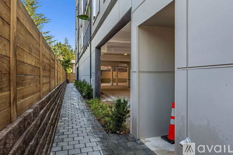 A narrow alley with a wooden fence on the left and a building with a white facade on the right.