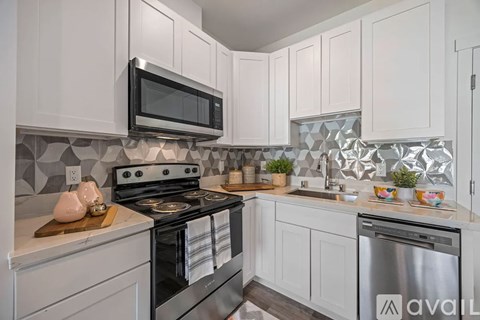 A kitchen with white cabinets and a black stove top oven.