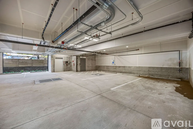 A large, empty industrial space with concrete floors and exposed pipes.