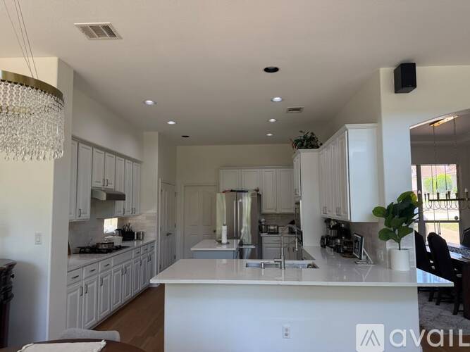 A large, well-lit kitchen with white cabinets and a central island.