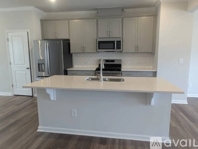 A kitchen with a white countertop and stainless steel appliances.