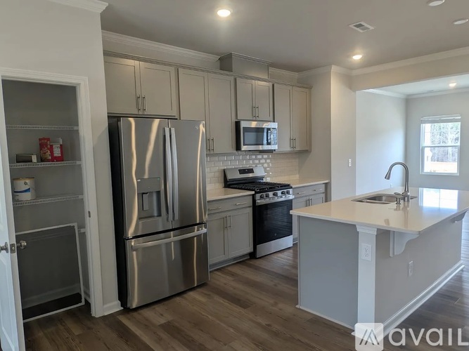 A kitchen with a refrigerator, oven, and microwave.