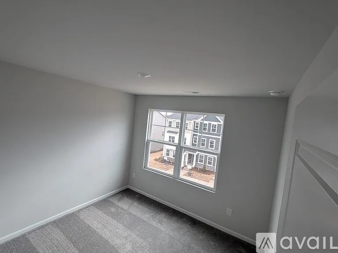 A room with a large window showing a building outside.