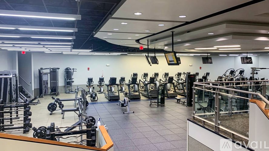 A gym with a variety of equipment including treadmills, weights, and exercise machines.