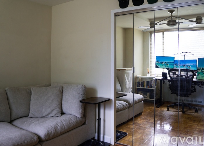 A living room with a couch and a glass door leading to a balcony.