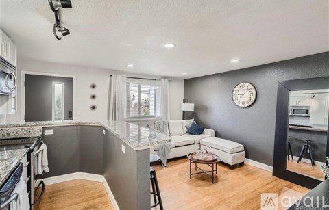 A modern kitchen with a white sofa and a grey wall.
