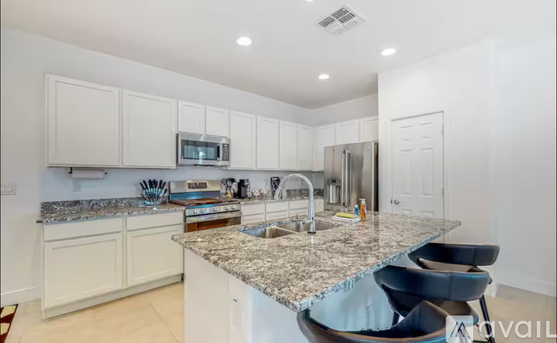A kitchen with white cabinets and a granite countertop.