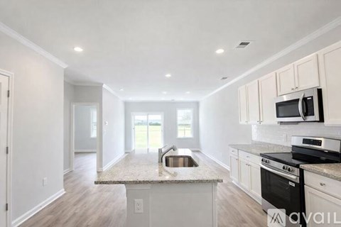 A kitchen with white cabinets and a granite countertop.