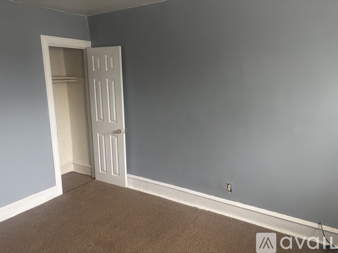 A room with a carpeted floor and a white door.