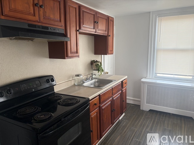 A kitchen with wooden cabinets and a black stove top oven.