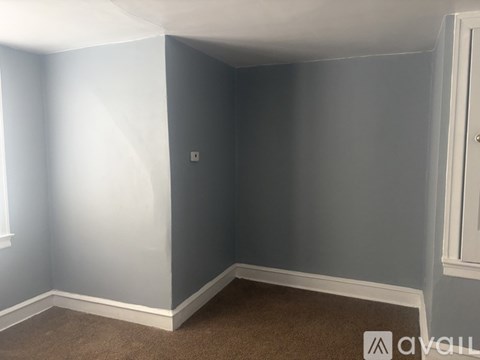 A room with a carpeted floor and a door on the right side.
