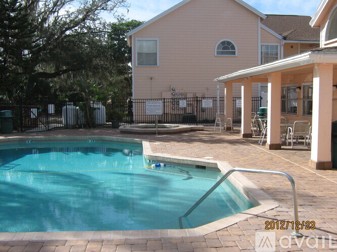 A pool in a backyard with a house in the background.