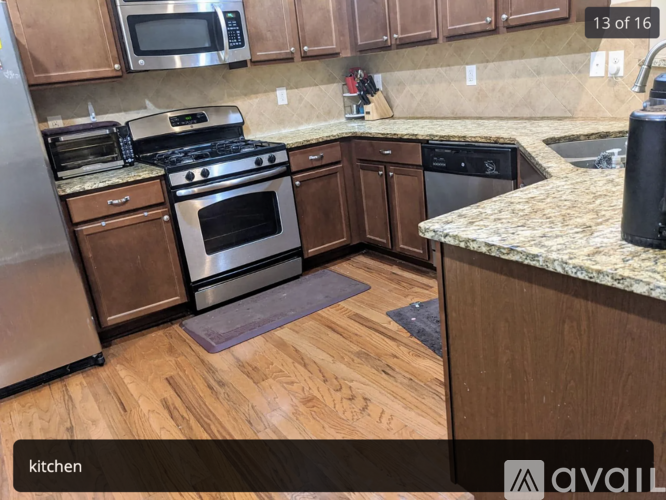 A kitchen with wooden cabinets and a granite countertop.