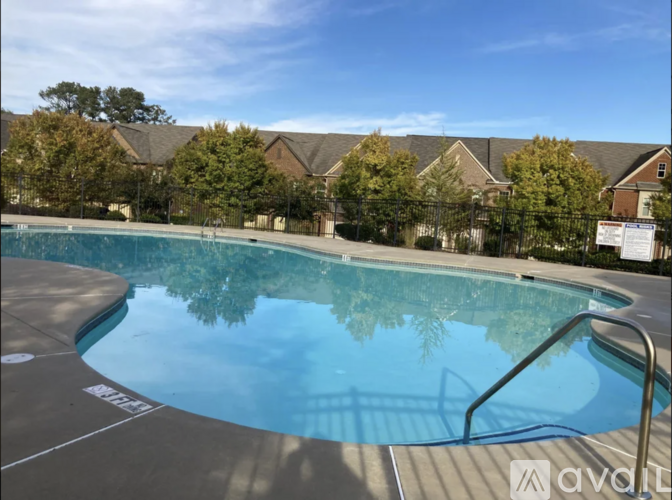 A swimming pool surrounded by a fence and trees.