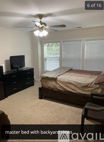 A bedroom with a master bed and a television.