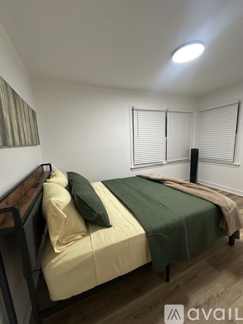 A bedroom with two beds and a wooden floor.