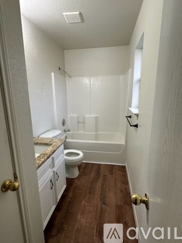 A bathroom with a toilet, sink, and bathtub.