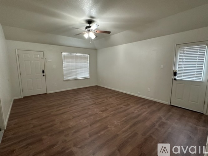A room with wooden flooring and a ceiling fan.