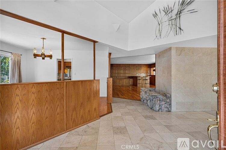 A living room with a wooden reception desk and a stone fireplace.