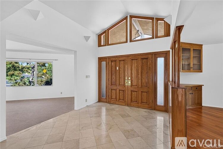 A spacious room with wooden cabinets and a checkered floor.
