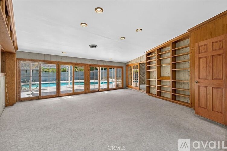 A spacious room with a pool visible through the sliding glass doors.