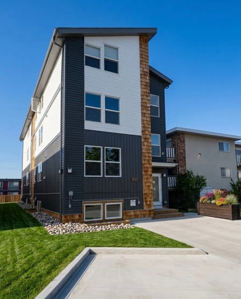 A modern two-story house with a combination of white and dark grey exterior.