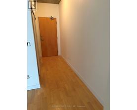 A hallway with a wooden door and floor.