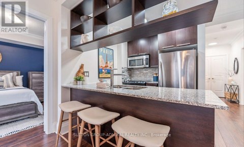 A modern kitchen with a stainless steel refrigerator and a breakfast bar.