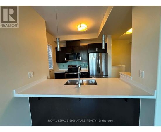 A kitchen with a sink and a refrigerator.