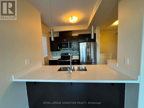 A kitchen with a sink and a refrigerator.