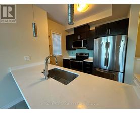 A kitchen with a sink and a refrigerator.