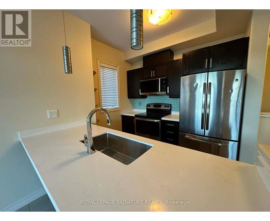 A kitchen with a sink and a refrigerator.