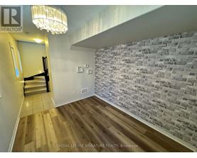 A room with a wooden floor and a brick wall.