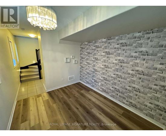 A room with a wooden floor and a brick wall.